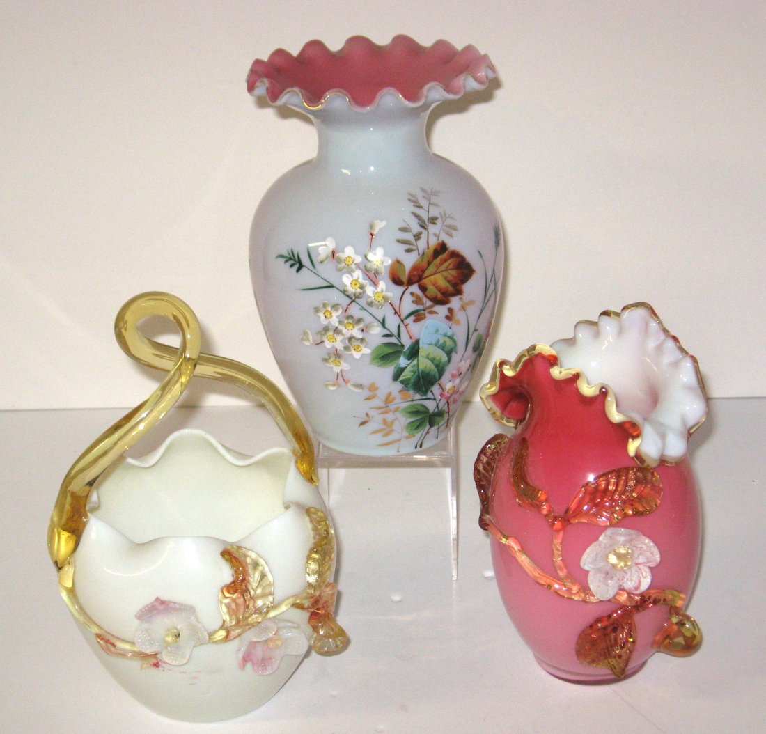Three decorative glass items,: Including a shouldered satin glass vase with enameled flowers, an opal glass basket with applied leaves, and a Peachblow vase with applied amber branch and flowers, tallest 8' ht.