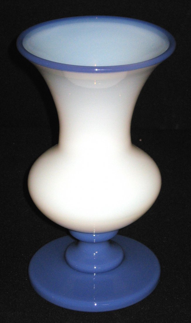 Fry Foval glass vase number 353,: Footed urn form Opal glass with a blue foot and lip wrap, 9" ht. LITERATURE: see Fry Collectors Encyclopedia page 165.