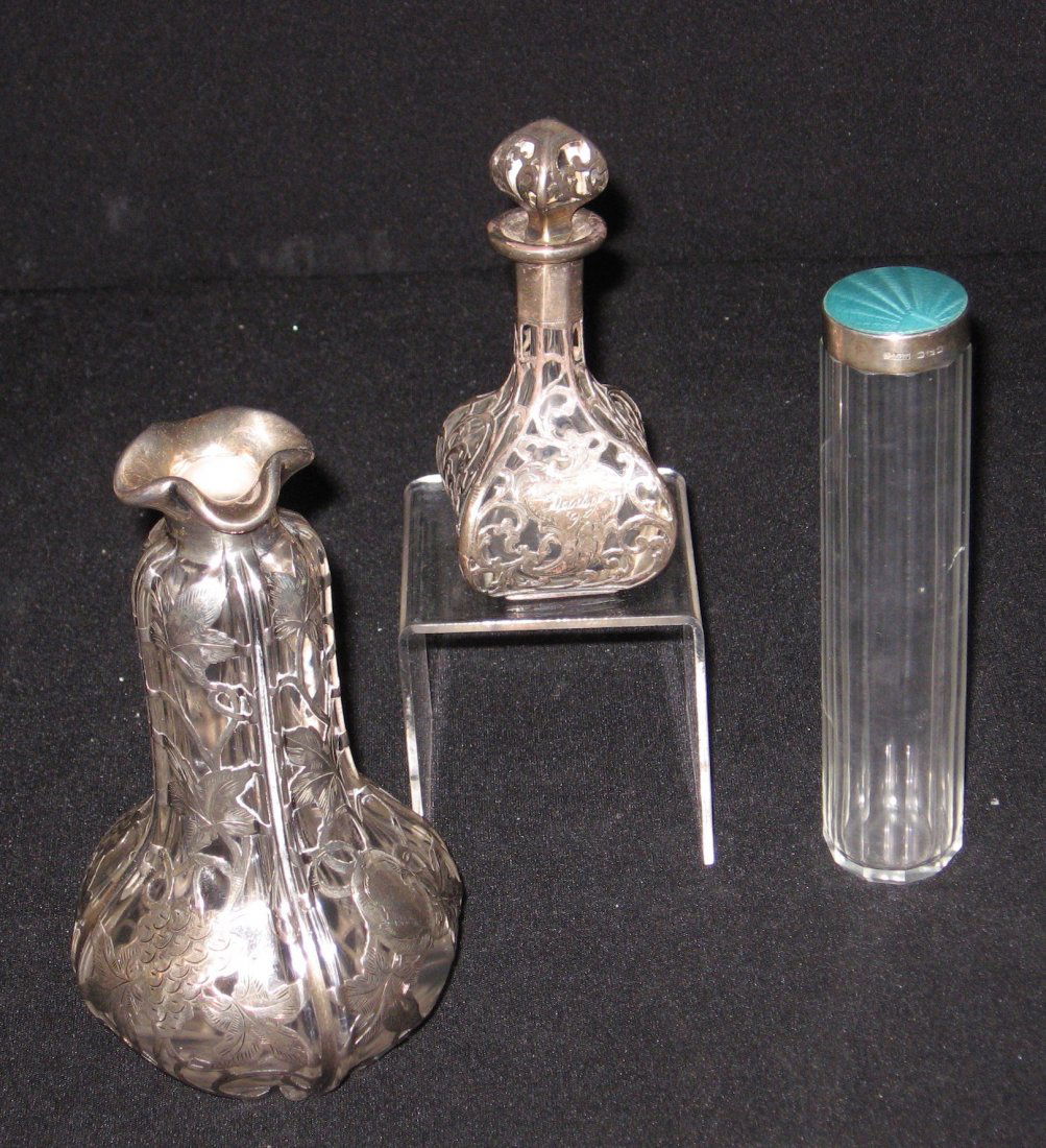 Three Silver and glass items,: Including a four sided silver overlay perfume with scrolling, a silver overlay vase with grapes and leaves, and a faceted bottle with blue enameled sterling cap marked B G & W, 7' ht.