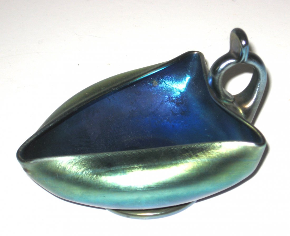 Tiffany Blue Favrile finger nappy,: Triangular blue Favrile nappy with a rolled over rim adorned with a ring finger handle, signed L. C. T. Favrile, 4 3/4" long.
