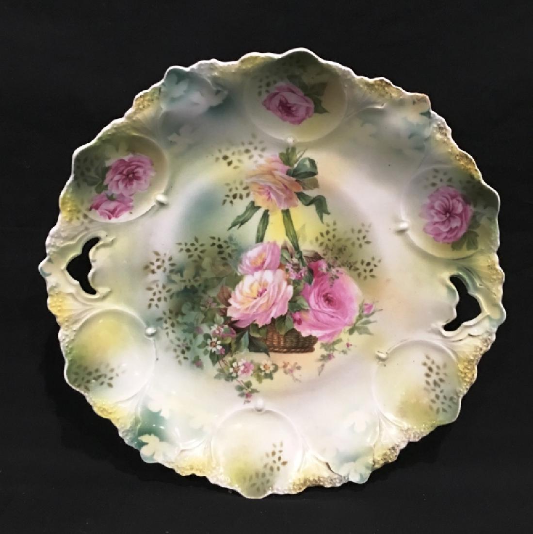 R.S. PRUSSIAN BOWL W/ CUT OUT HANDLES: 10.5" IN DIAMETER, MARKED ON REAR, FLOWERS IN HANGING BASKET