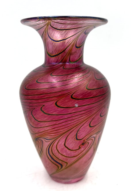 Robert Held Hand-Made Canadian Magenta Art Glass V: A single shimmery magenta art glass vase by Robert Held, featuring a flared rim, swirling blue and green threads, and a base label reading "ROBERT HELD HAND-MADE IN CANADA ART GLASS", it is 6.5 inches