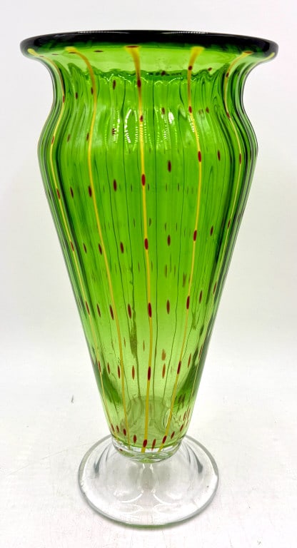 Tall Ribbed Green Art Glass Vase Yellow Stripes Re: A tall, ribbed art glass vase featuring a green body decorated with applied vertical yellow lines and small red dots, resting on a clear pedestal base, it is 12.5 inches tall and 5.5 inches across, pl