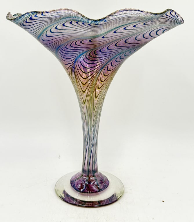 Robert Held Iridescent Art Glass Centerpiece Vase: A single tall, iridescent art glass vase/centerpiece features swirling pink, purple, blue, and gold threads, a clear circular base, and is inscribed R. Kehl Art Glass on the bottom, it is 10.375 inche