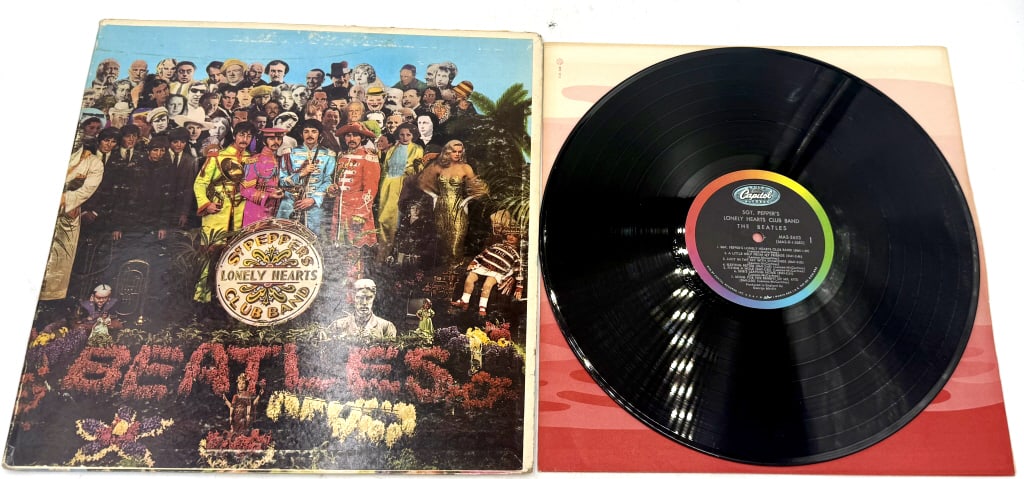 The Beatles Sgt. Pepper's Lonely Hearts Club Band: A single black vinyl LP of The Beatles Sgt. Pepper's Lonely Hearts Club Band in a multi-colored gatefold sleeve, featuring the Capitol Records Rainbow/swirl label design, catalog number MAS-2653, and 
