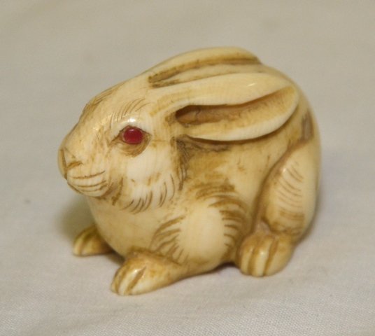 IVORY NETSUKE: Rabbit with red eyes, signed on bottom, 1 1/2\" wide by 1" tall