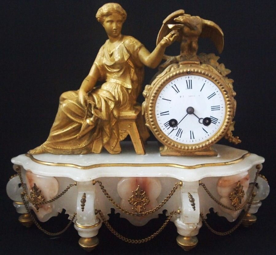 Majestic 19th C French Gilt Figural Mantle Clock: Superb ormolu trims, a maiden sitting and offering a drink to an eagle, beautiful chain decoration on the front with very sweet touched of pink in the alabaster pattern mounts adjustable ormolu feet.