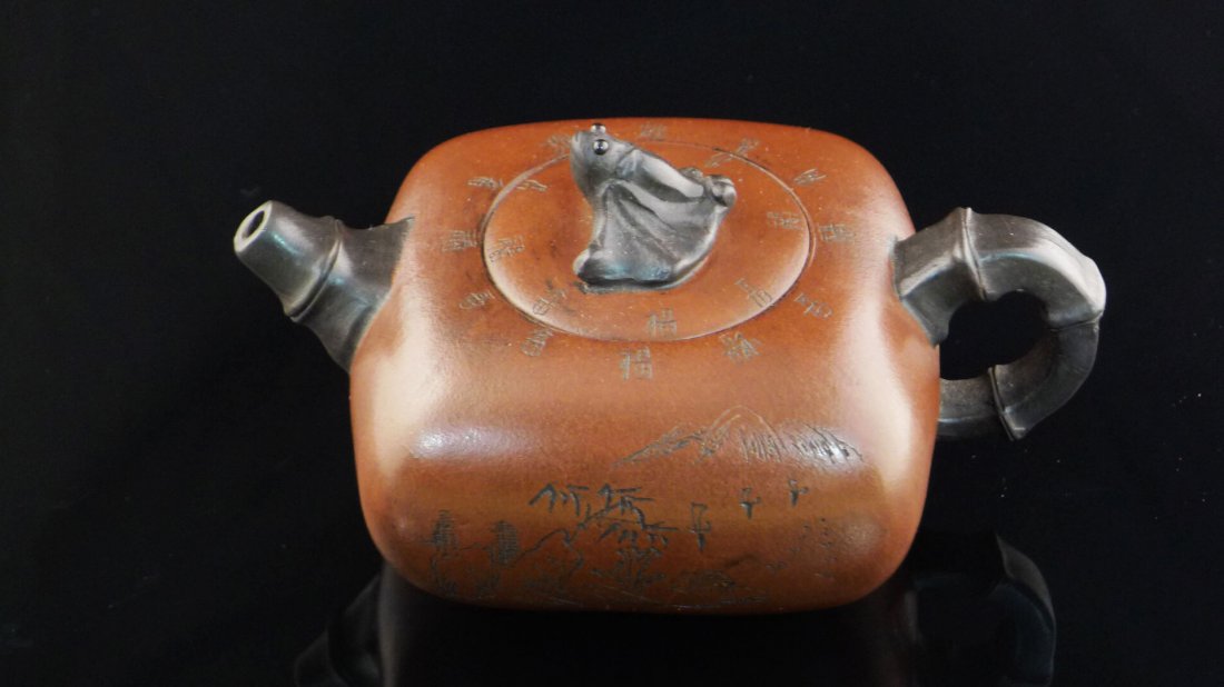 Chinese Yixing Clay Teapot: Chinese Yixing Clay Teapot with bat and landscape design, and a seal mark on the bottom, 3" x 6" x 4".