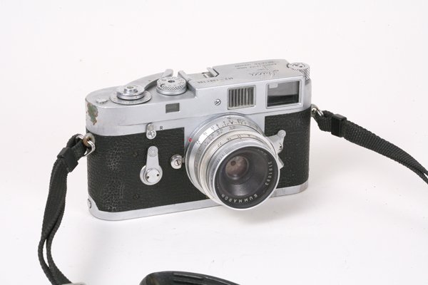Leica M2 Nr. 1061196 with 35mm Summaron f2,8.: Leica M2 Nr. 1061196 with 35mm Summaron f2,8Nr. 2101093, strap, lens cap, Leitz UVa, 12585H hood.Very heavy signs of use on the camera body. Specks of dust in the lens.