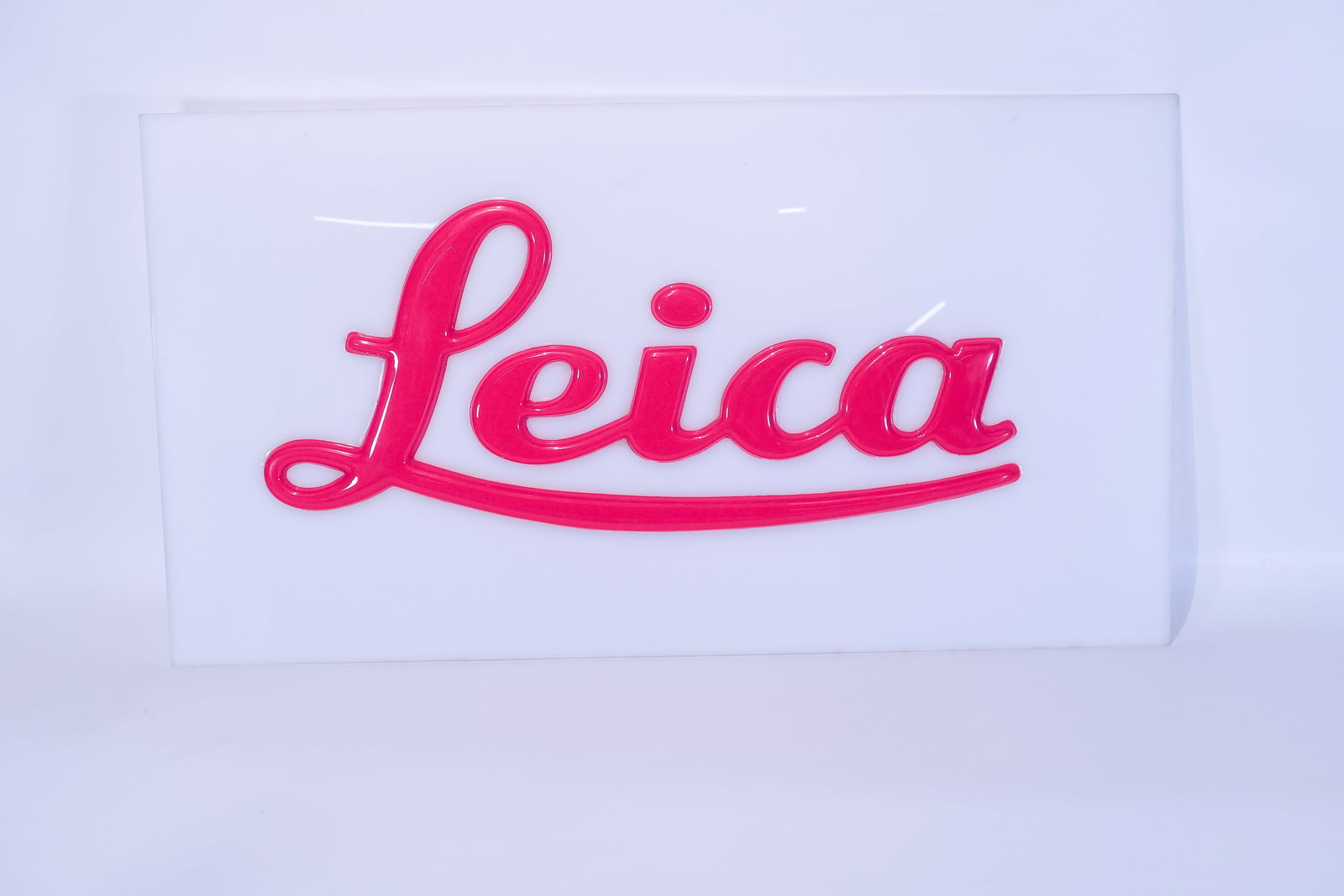 Plexiglass Leica sign with raised and rounded red lettering: Plexiglass Leica sign with raised and rounded red lettering. A very handsome sign measuring 26" wide by 14" tall. Apparently never used.Condition: Near Mint