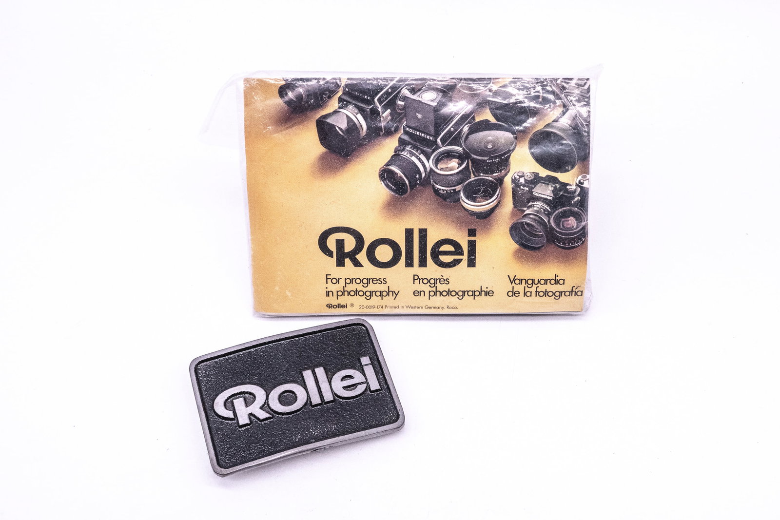 The Rollei belt buckle and “Rollei For Progress in Photography" Jigsaw Puzzle: The Rollei belt buckle and “Rollei For Progress in Photography” Jigsaw Puzzle, two fun promotional items.Condition: Near Mint overall
