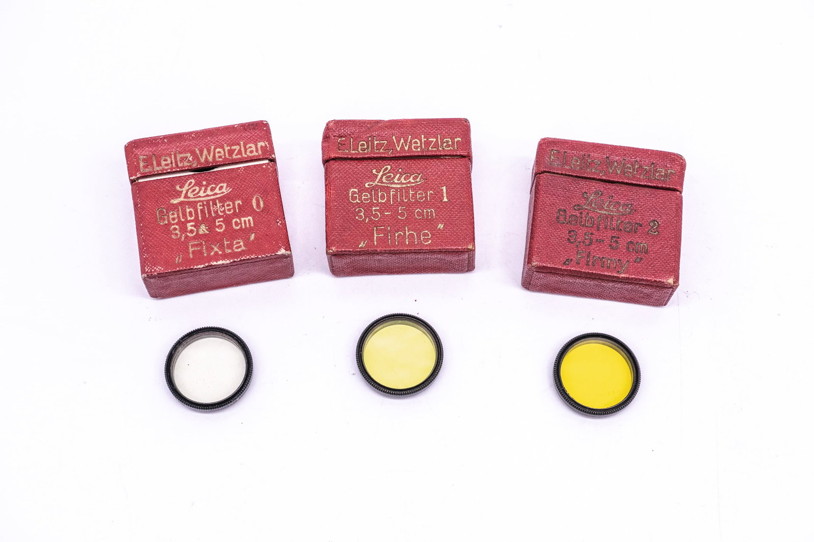 Three early filters for the 50mm Elmar and 35mm Elmar lenses: Three early filters for the 50mm Elmar and 35mm Elmar lenses, in their red paper boxes: Yellow “0” FIXTA, Yellow “1” FIRHE and Yellow “2” FIRMY. All marked with asterisks.Condi
