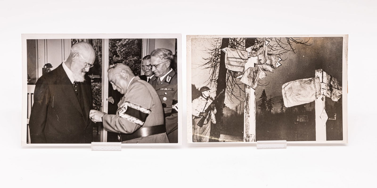 Two original photographs by Heinrich Hoffmann: Two original photographs by Heinrich Hoffmann. These 5x7-inch photographs show an American soldier adjacent to hidden directional signs and Dr. Robert Bosch being awarded the "Pioneier der Arbeit" (Pi