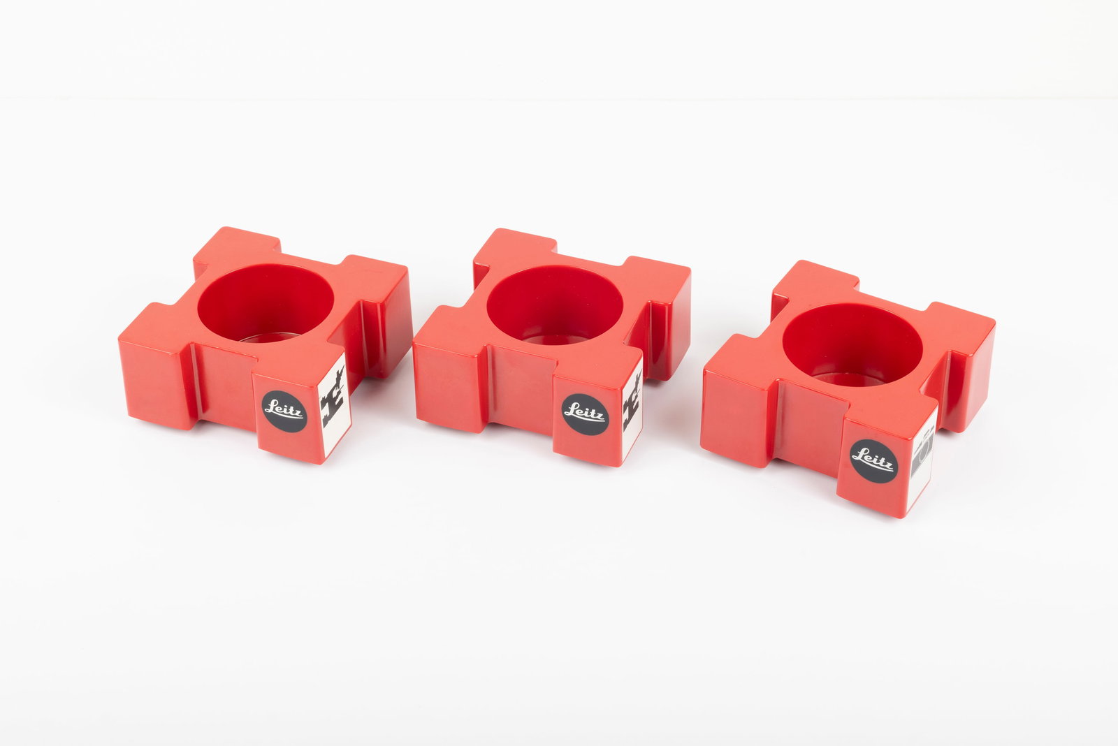 Three Leitz red plastic lens display stands - 2