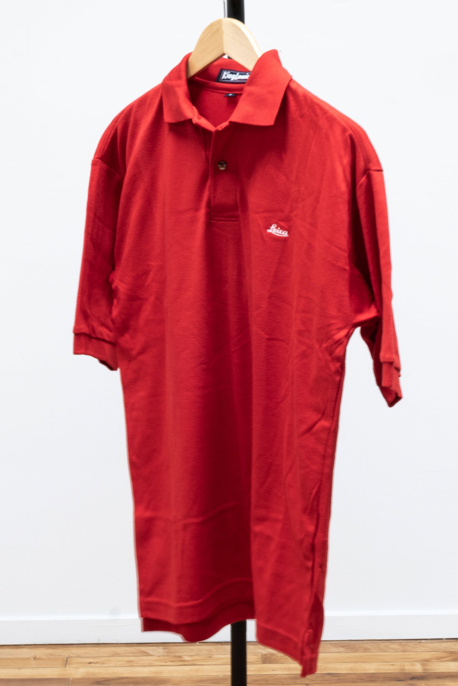 Three Leica Polo shirts: Three Leica Polo shirts, in Medium size. The white Polo shirt bears the Leica Red Dot on the left sleeve. The Red shirt displays a thin Leica script on the left breast. The green Polo displays the