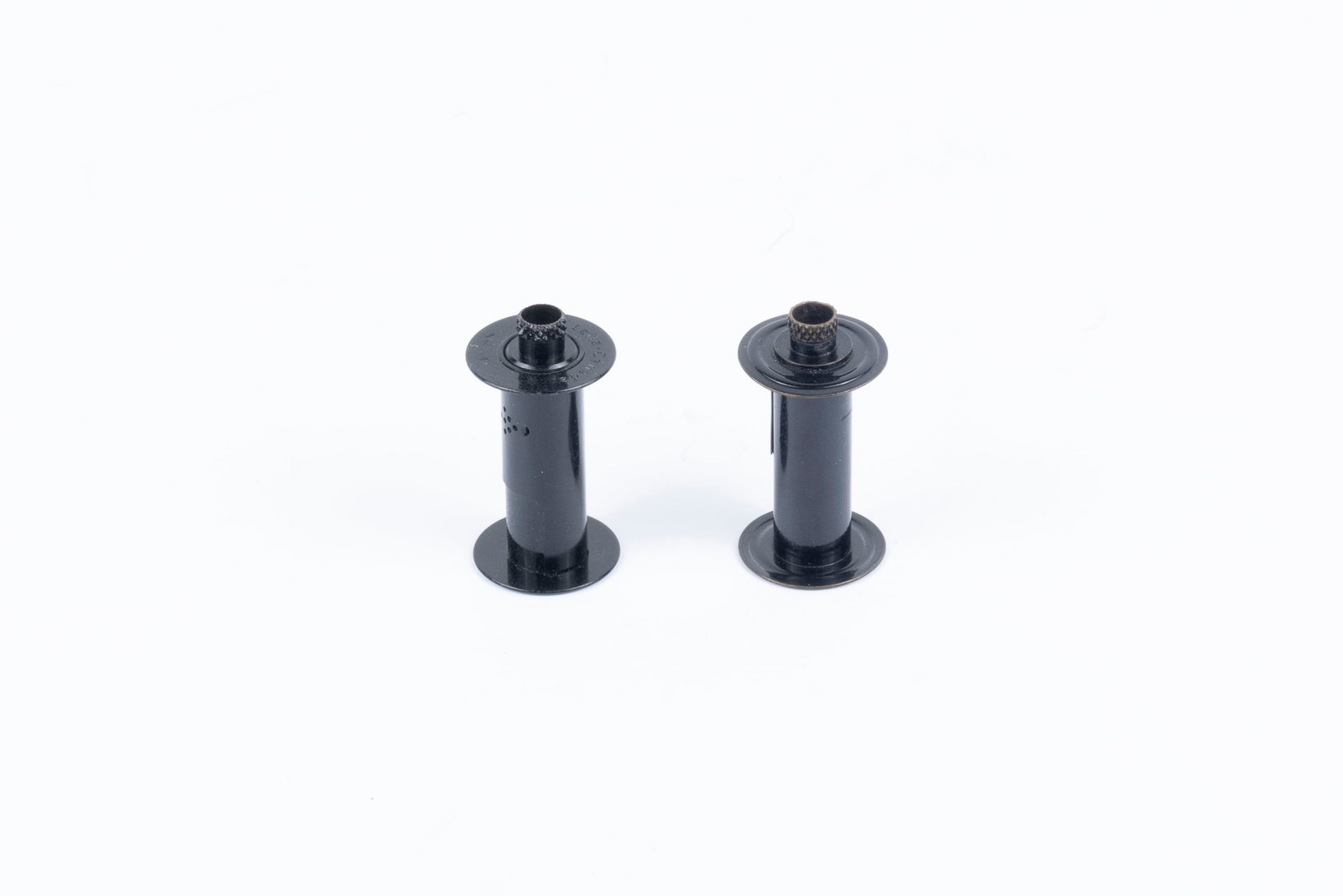 Two rare Leica take-up spools: Two rare Leica take-up spools for screw-mount cameras: the early Leica I (Model A) spool with ridged top and slight patina, and the later spring-loaded type, engraved "Leitz Canada," apparently