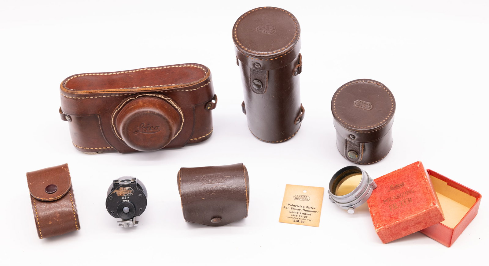 E. Leitz New York leather cases: An array of E. Leitz New York leather cases and accessories: ever-ready case with newer stitching, two lens cases (50mm and 135mm), a universal viewfinder VIDOM case, a universal viewfinder IMFIN