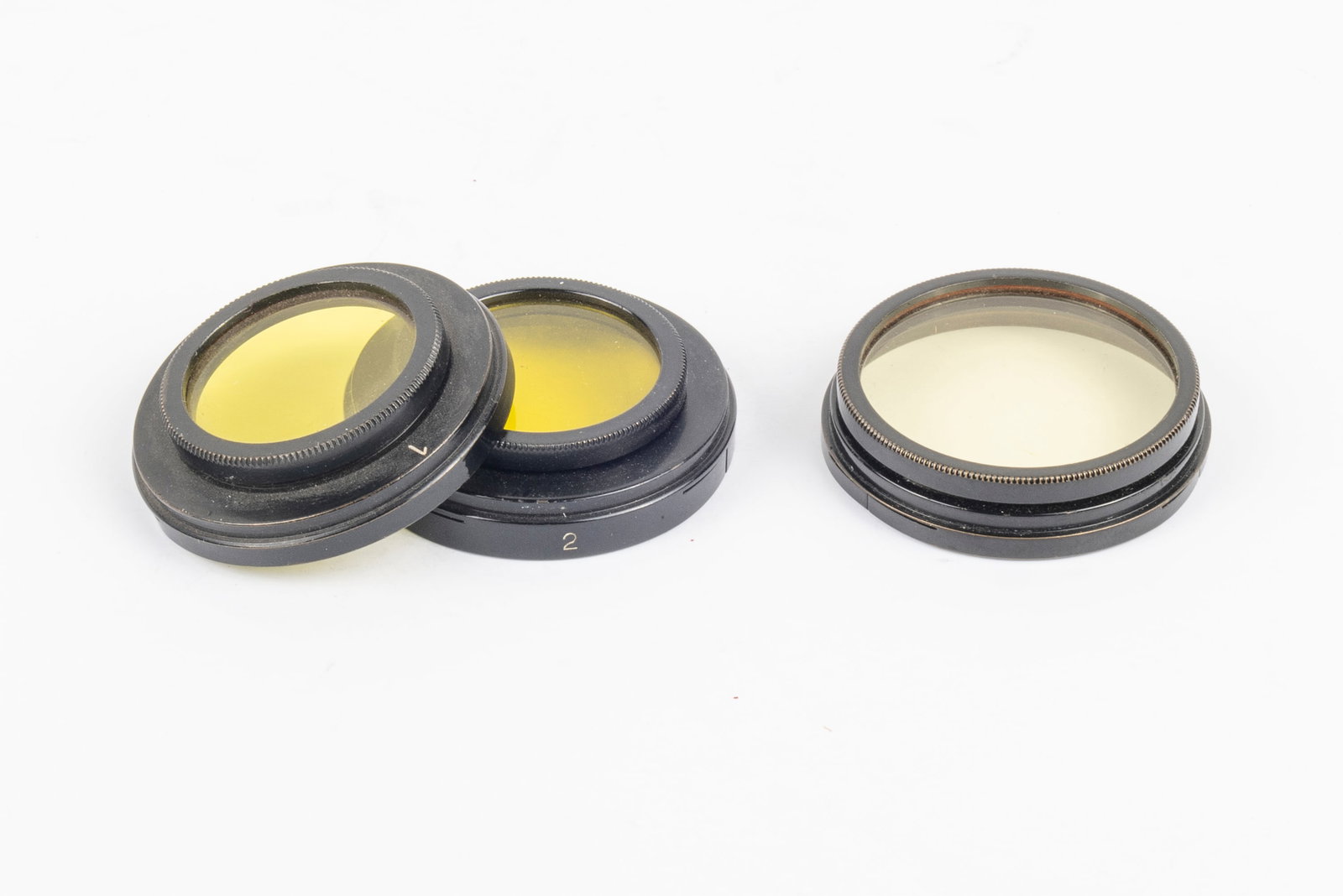 Three early yellow slip-on filters: Three early yellow slip-on filters for the 50mm and 35mm Elmar lenses: yellow No. 1 filter FILBY and yellow No. 2 filter FILGE. Also included is an early slip-on very light yellow filter simply marked