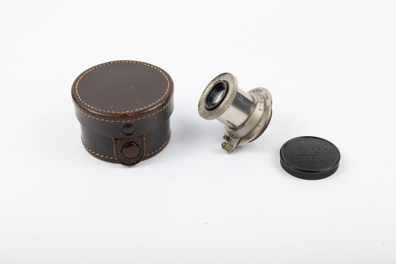 50mm Elmar f3,5 Nr. 127471: 50mm Elmar f3,5 Nr. 127471, with Bell-Push infinity lock and Bakelite cap in leather case. With slight haze, appropriate to its age. Condition: Excellent ++