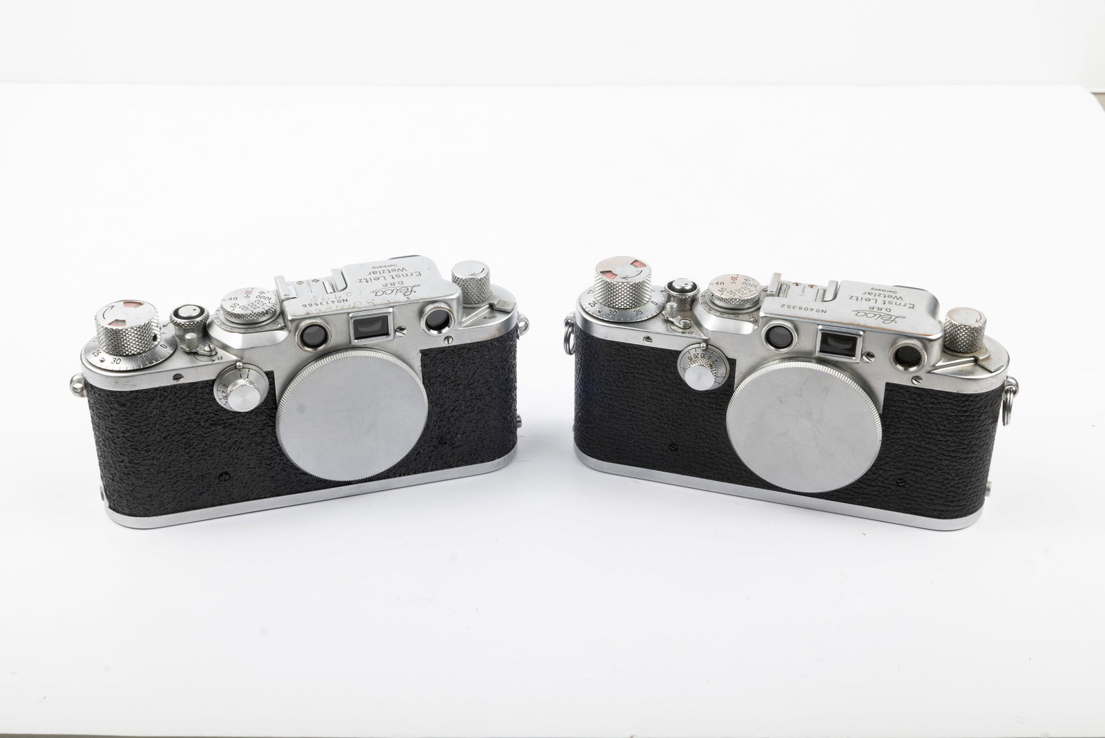 Two Leica IIIc-IIIf Black Dial conversion cameras: Two Leica IIIc-IIIf Black Dial conversion cameras. Nr. 406352 and Nr. 413566. Both cameras have working shutters and rangefinders. One camera is recovered and missing take-up spool, but less in need o