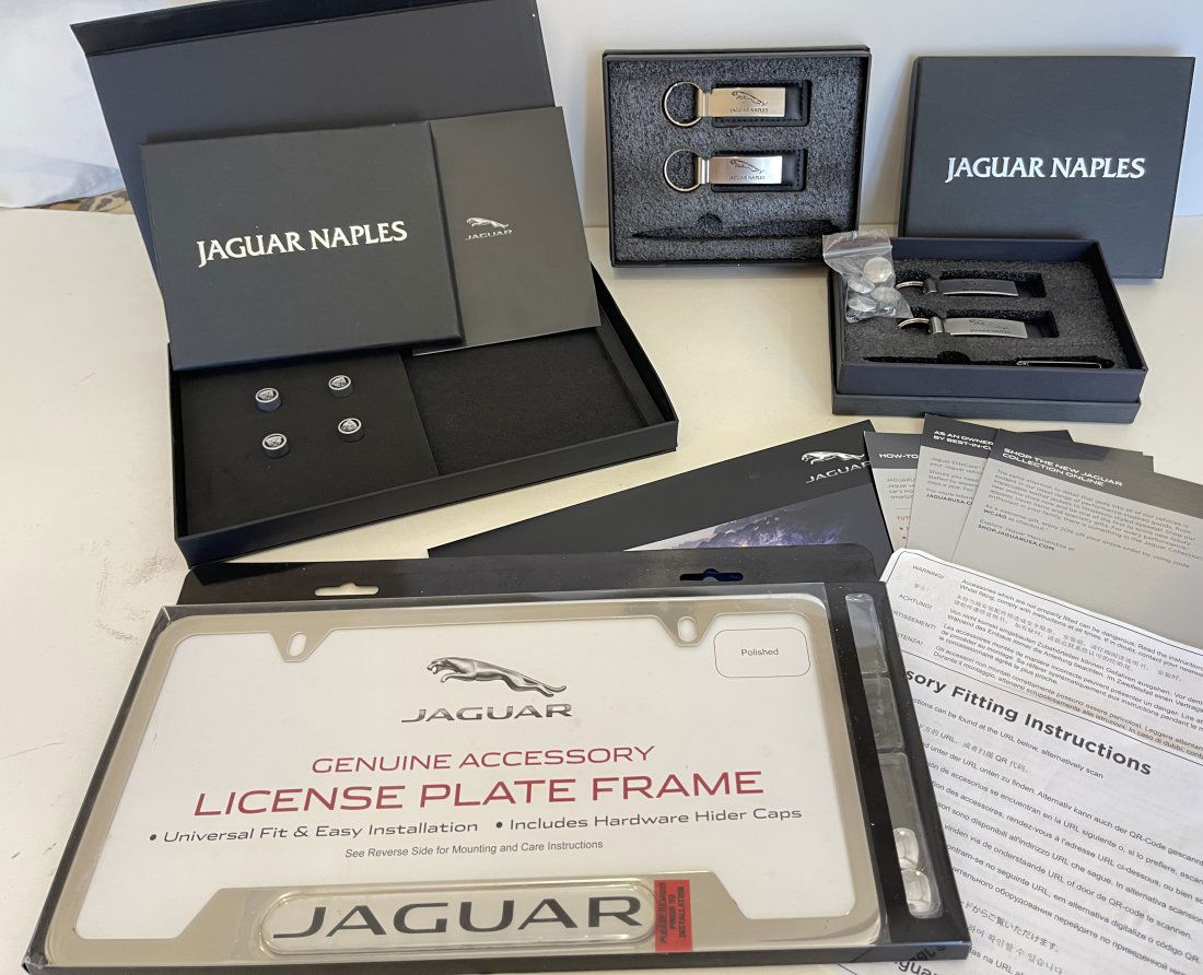 JAGUAR COLLECTOR ITEM SET: JAGUAR COLLECTOR ITEM SET INCLUDING LICENSE PLATE HOLDER, TIRE CAPS, KEYCHAINS, PEN, BOOKS AND PAPERWORK.