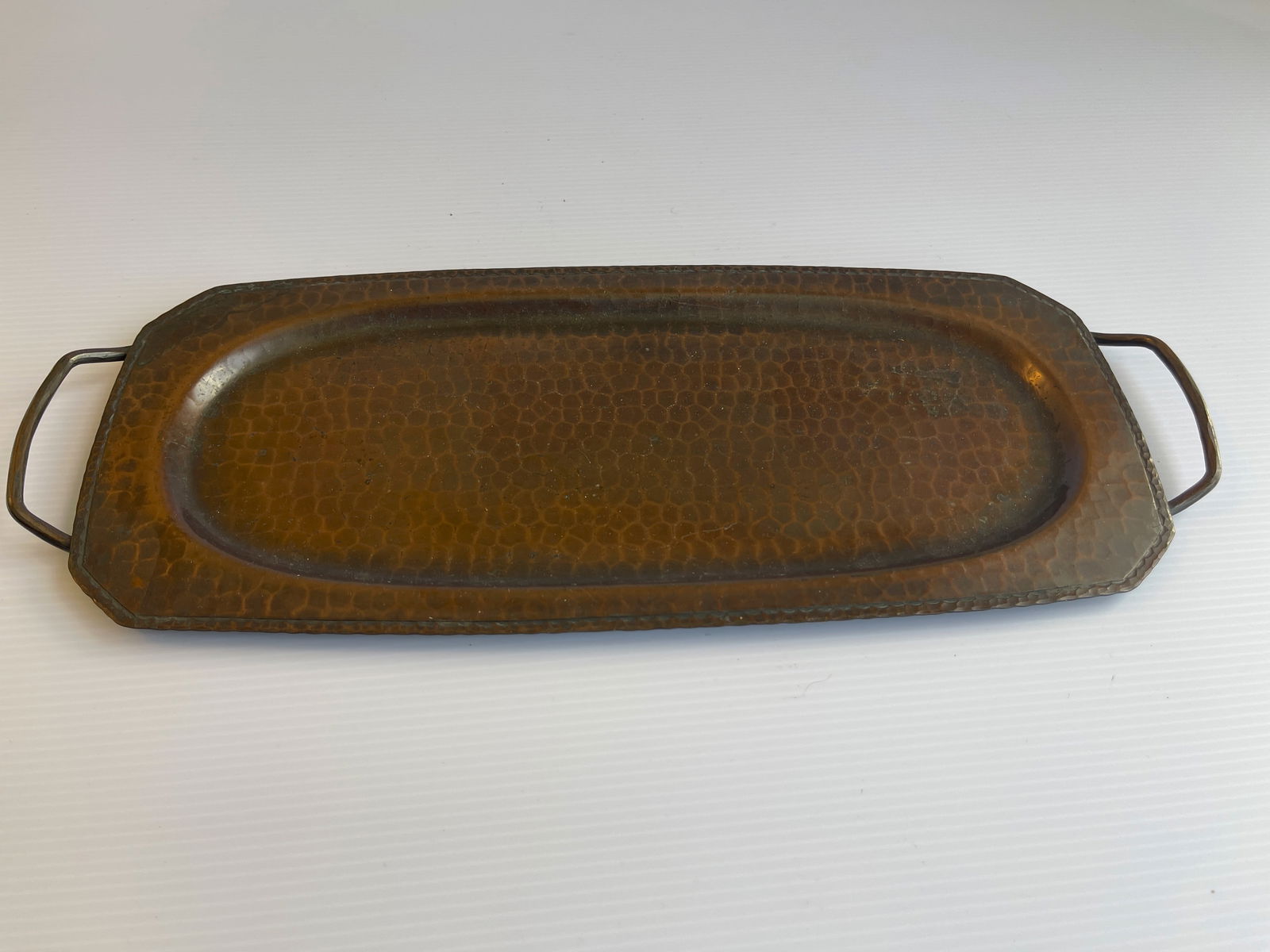 ROYCROFT HAMMERED COPPER TWO-HANDLED SERVING TRAY: ROYCROFT HAMMERED COPPER TWO-HANDLED LONG SERVING TRAY. CIRCA 1920S. 13 X 6. WIDEST AT HANDLES IS 14.75.