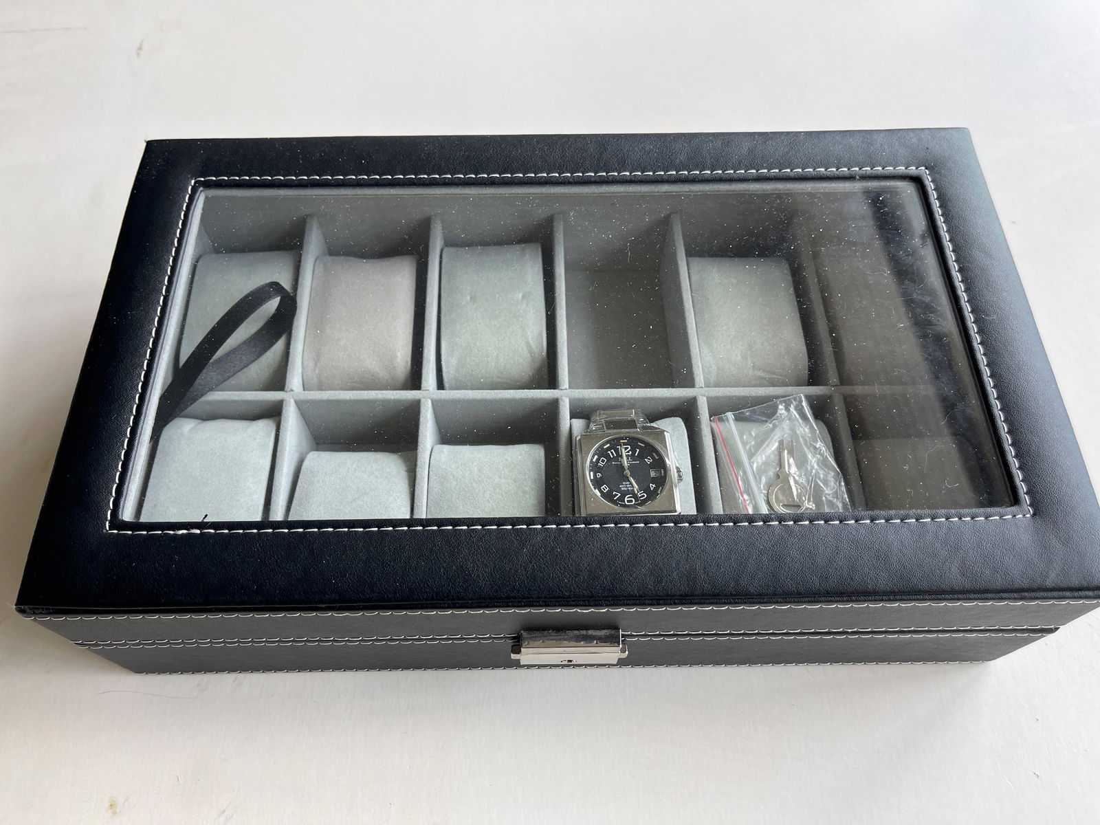 BALL WATCH AND 12 WATCH DISPLAY CASE SET: BALL WATCH AND 12 WATCH LOCKING DISPLAY CASE SET. WITH KEY. MISSING 1 WATCH PILLOW. INCLUDES KEY. BALL Inspector Quartz Blue Dial Men's Watch Item No. NM1021D-S. WITH TAGS. WATCH DOES NOT COME WITH BO
