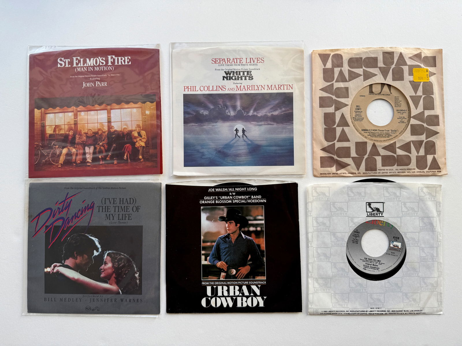 MOVIE SOUNDTRACK 45s SET 5: ST. ELMO’S FIRE. PHIL COLLINS WHITE NIGHTS. ROCKY GONNA FLY NOW. DIRTY DANCING. URBAN COWBOY. FOR YOUR EYES ONLY.