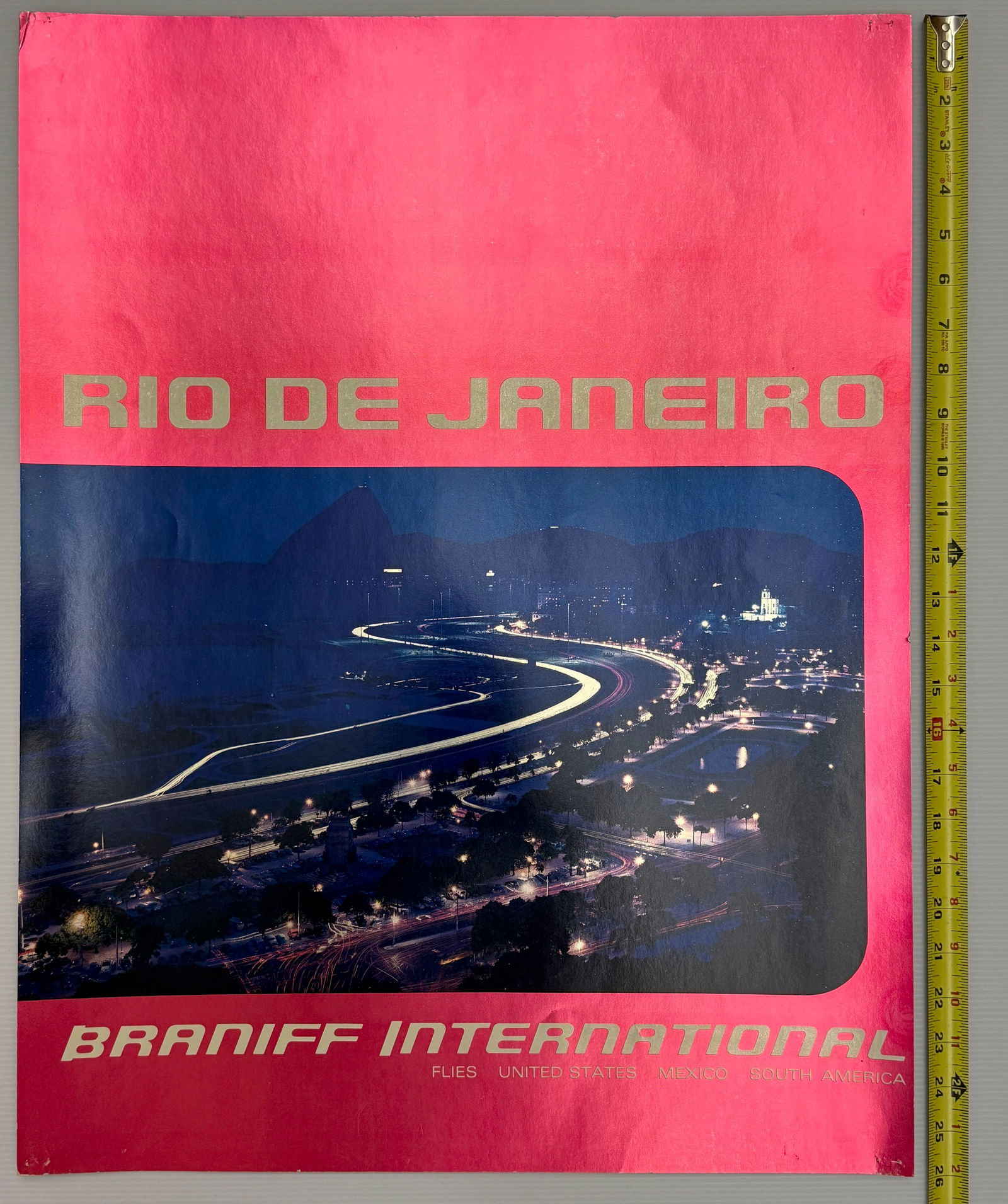 Original Braniff International Airways vintage travel poster: This is an original Braniff International Airways vintage travel poster advertising flights to Rio de Janeiro, Brazil. The specific poster pictured features a night view of the city and was issued in