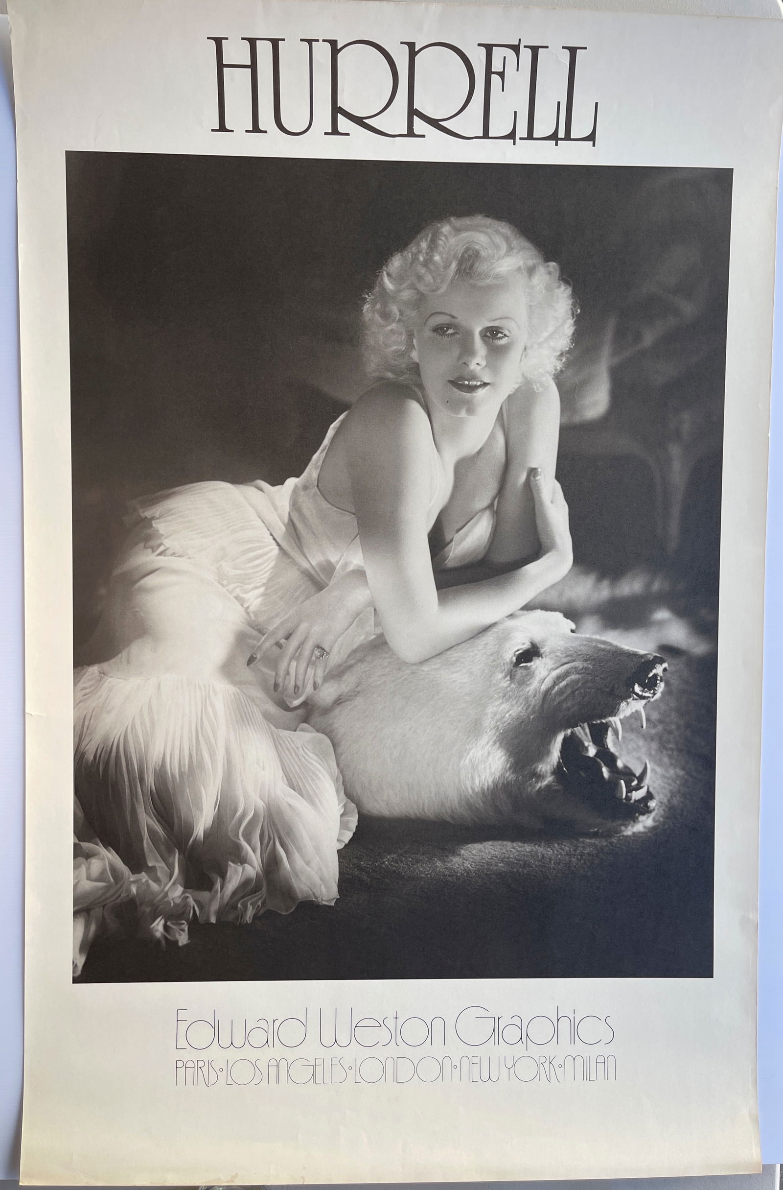 Jean Harlow by George Hurrell: This is a vintage poster featuring a famous photograph of actress Jean Harlow taken by the Hollywood photographer George Hurrell. The photo, taken around 1934-1936, shows Harlow reclining on a polar b