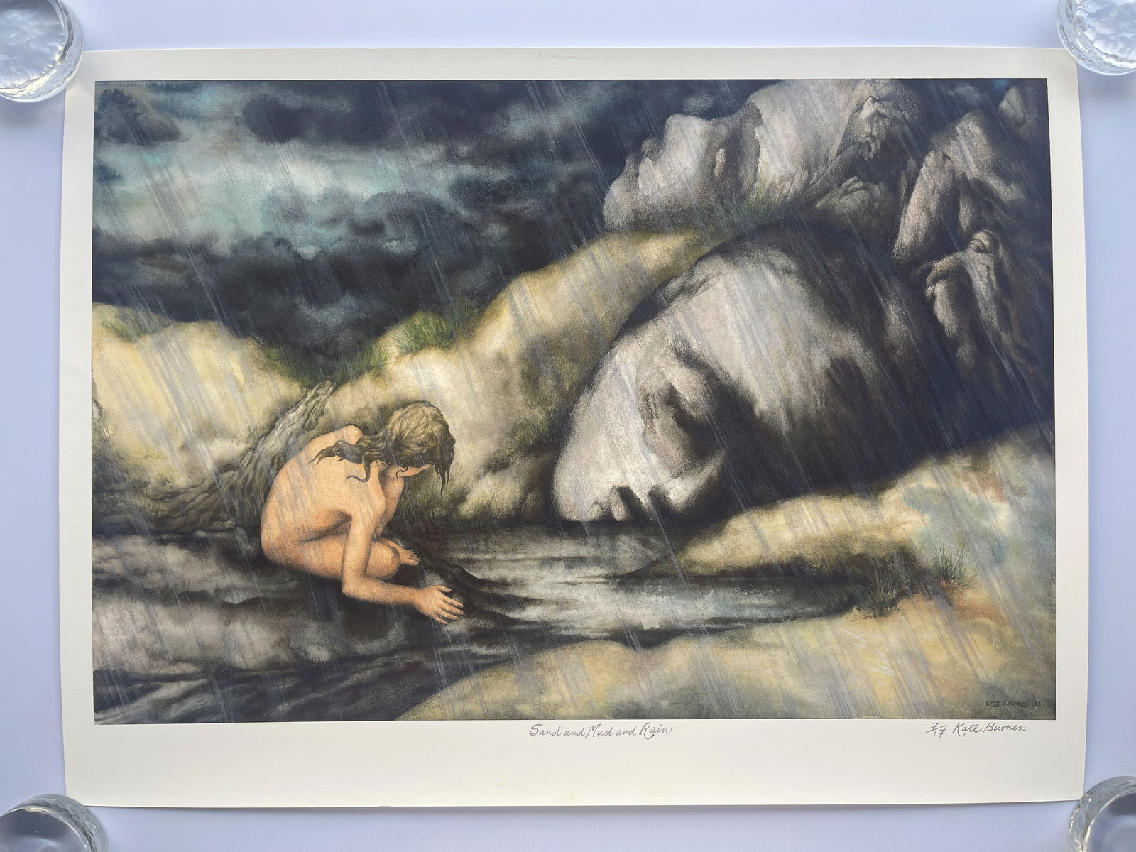 Sand and Mud and Rain" by artist Kate Burness: The image provided is a print of an artwork titled "Sand and Mud and Rain" by artist Kate Burness. The artwork is part of her "Goddess - The Sacred Feminine" collection and often features the female f