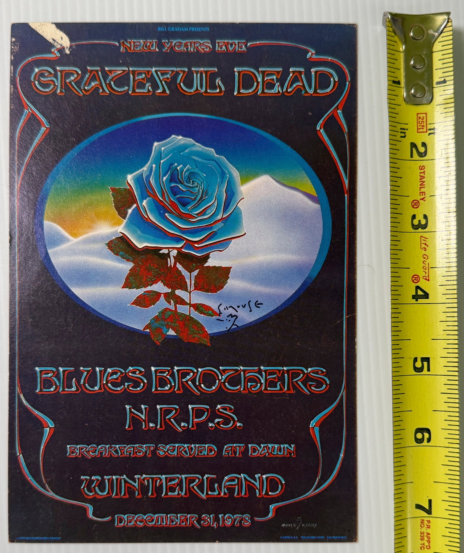 GRATEFUL DEAD BLUE ROSE HANDBILL SIGNED BY MOUSE: GRATEFUL DEAD BLUE ROSE HANDBILL SIGNED BY STANLEY MOUSE. ABOUT 5 X 7. 1ST. Bill Graham's famous 'breakfast served at dawn' promise was a time-honored New Year's tradition by the time the Grateful
