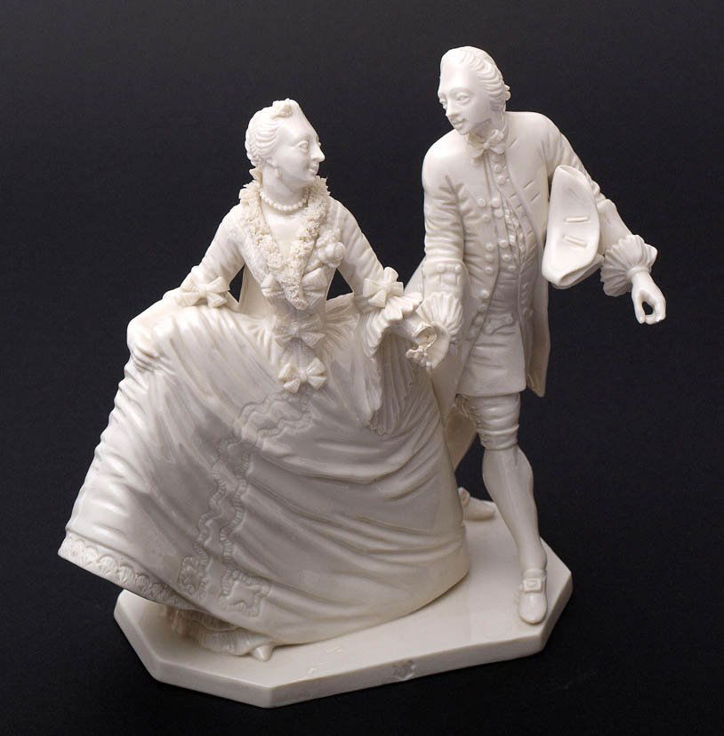 Figurengruppe, Nymphenburg: Entwurf von Franz Anton Bustelli. Auf rechteckigem, an den Ecken abgteschrägtem, flachem Sockel höfisch gekleidetes Paar. Cremeweiß glasiertes Porzellan. Pressmarke, Modellnummer 12. H.18,5cm. Aus