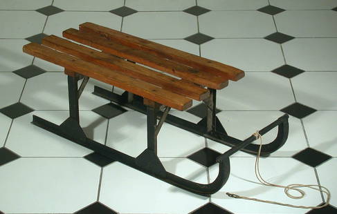 Kinderschlitten, 19.Jhdt.: Kufen und Sitzhalterung aus Schmiedeeisen. Sitz aus massiven Holzlatten. L.84, B.36, H.28cm.