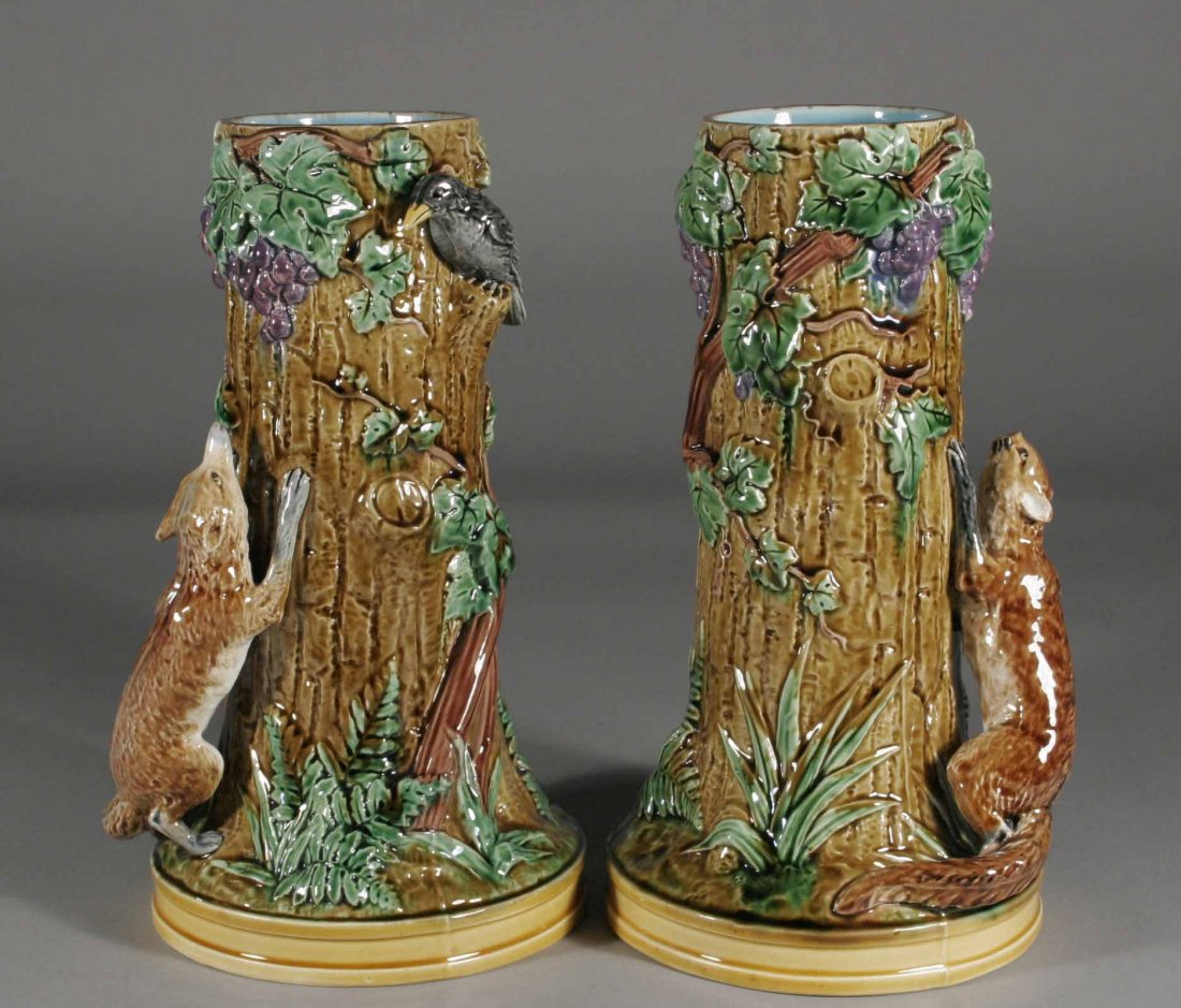 A pair of Mintons Majolica spill vases, each natur: A pair of Mintons Majolica spill vases, each naturalistically modelled as a tree ornamented with vine work and portraying a fox chasing a blackbird, impressed Mintons and model number 1748, 9''.