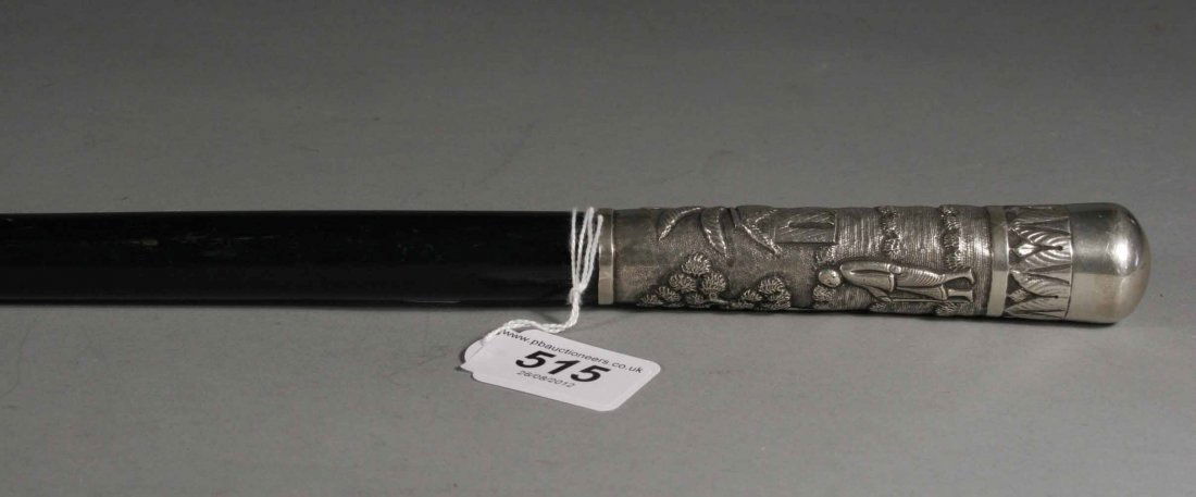 An ebonized walking cane with chased Indian silver: An ebonized walking cane with chased Indian silver mounts each depicting continuous landscapes populated with figures, 30''.