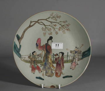 A nineteenth century Chinese Celadon dish decorated: A nineteenth century Chinese Celadon dish decorated in famille rose enamels with figures in an outdoor setting, Daoguang seal mark in blue, 10.25'' diameter.