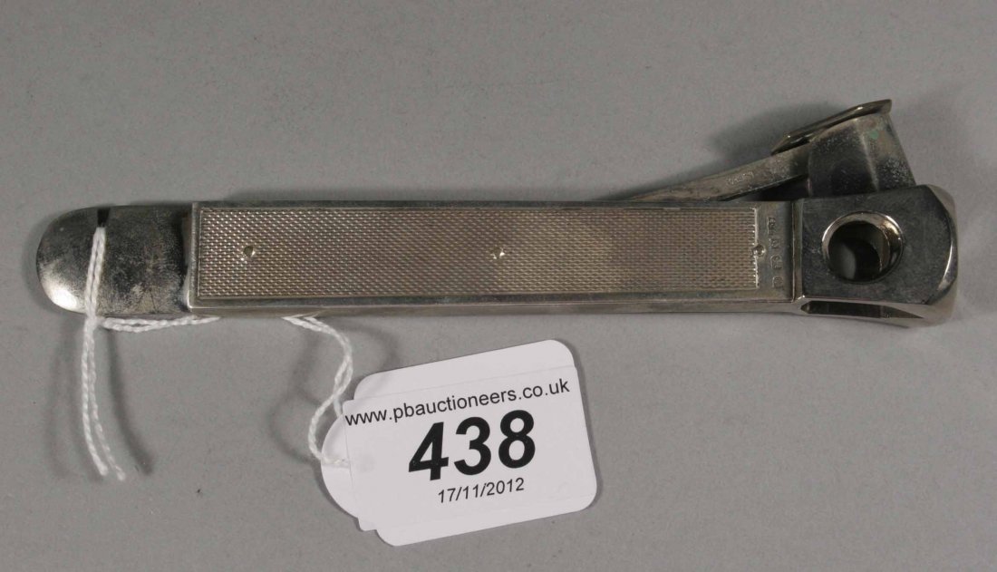 A silver cigar cutter with engraved scales, assaye: A silver cigar cutter with engraved scales, assayed Birmingham 1976, 6''.