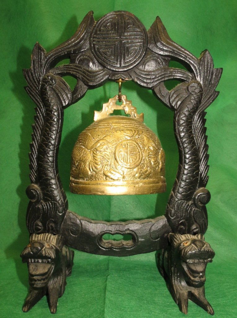 Bronze Chinese Bell with Carved Wood Stand: H 13" x W 9" x D 5" Chinese brass bell with carved wooden stand. Has figural kylin beast feet on stand with dragon fish design on frame. Raised depictions of Phoenix birds and clouds on bell. Qing Dyn