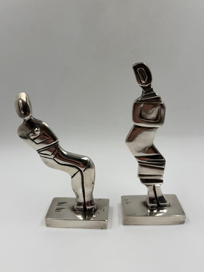 Marta Minujin Pair of Silverplated Bronze Sculptures H: 4. 8" & 3.8": Shipping in - House available.Marta Minujin was born in 1943 in Buenos Aires. She studied fine art at the Escuela de Bellas Artes Manuel Belgrano and art education at the Escuela Superior de Bellas Ar