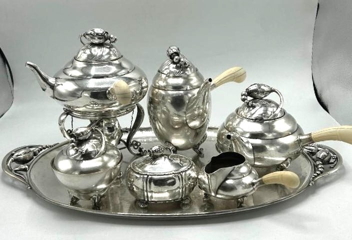 Georg Jensen Sterling Silver Art Deco 7 Pieces Tea Set , Tray 22"x13" - W: 165 oz: Samovar H: 10" Coffee Pot H: 8" Shipping In - House available - Born in 1866, Jensen was the son of a knife grinder in the town of Raadvad just to the north of Copenhagen. Jensen began his training in