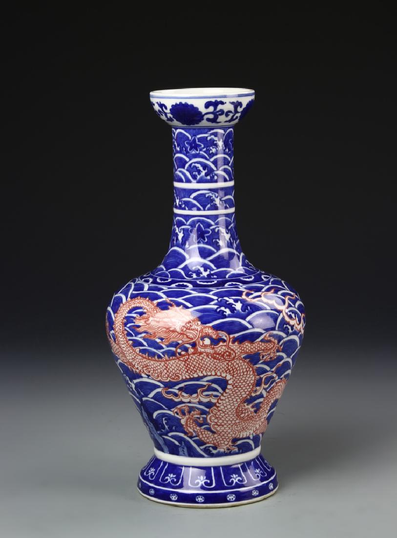 Chinese Blue and White Dragon Vase: China, ROC, blue and white vase, decorated with bolds, copper red dragon, against dense mass of crested waves and clouds in deep blue shades, Qianlong mark. Height 11 in.
