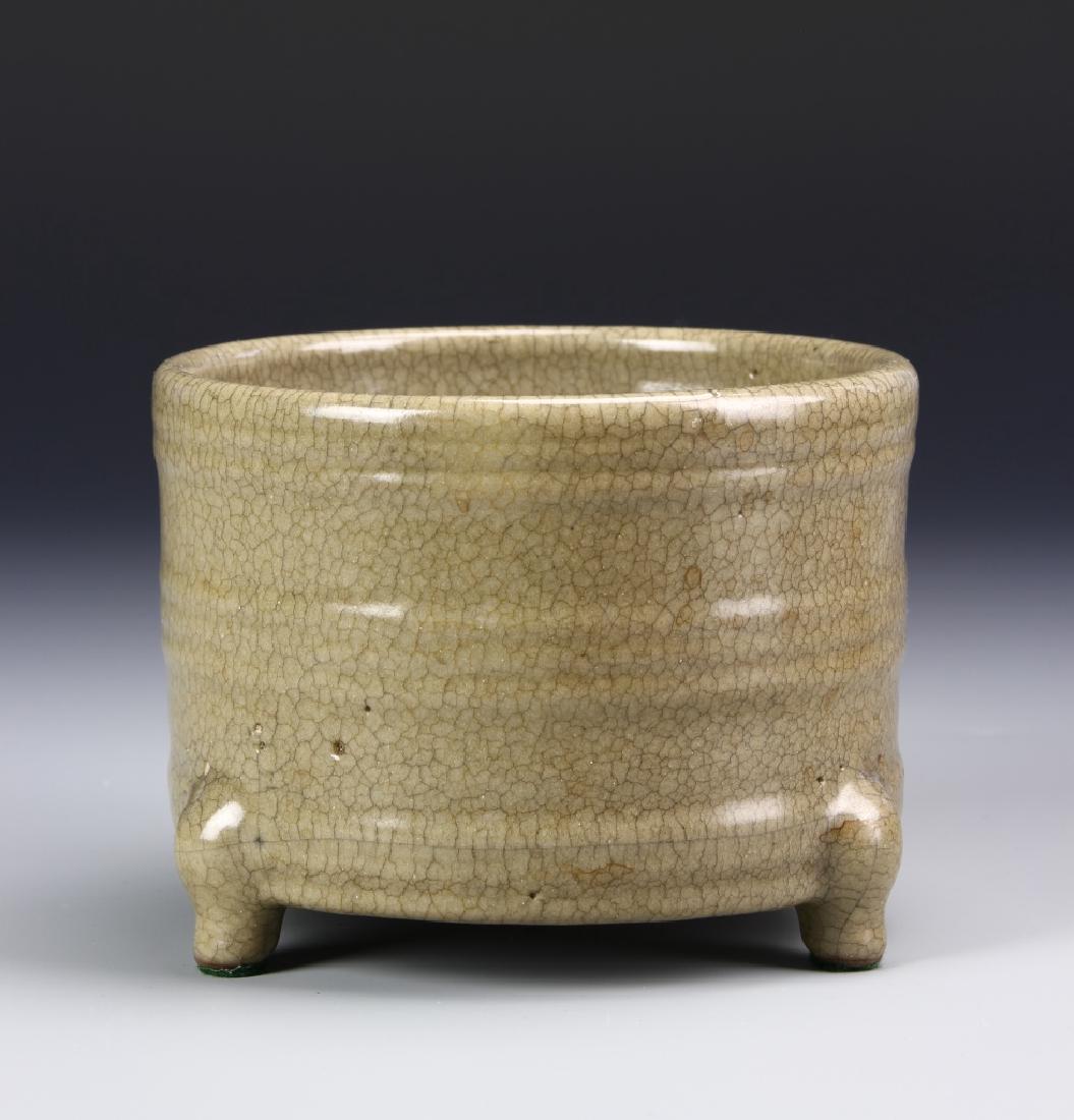 K'uan-Type Tripod Censer: Of cylindrical body molded with raised bands and supported on three cabriolet legs, covered overall with a lustrous warm russet glaze suffused with dense crackles, spur mark on the base and interior, 