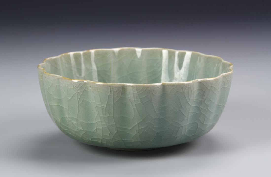 K'uan-Type Lungchuan Bowl: Of curved fluted sides supported on a small recessed foot, covered allover with a lustrous olive-green glaze suffused with fine crackles, base with spur marks, 5.7 in wide. Provenance: From the collec