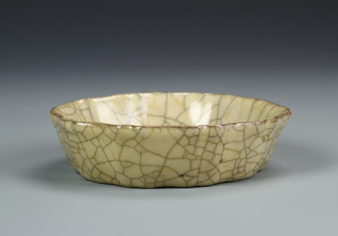 Ge-type Mallow-Shaped Brush Washer: The flared sides folded into ten lobes divided by a notched facet to the rim, covered overall with a thick ivory glaze suffused with wide iron-gray crackles interspersed with fine golden crackles, 5 i