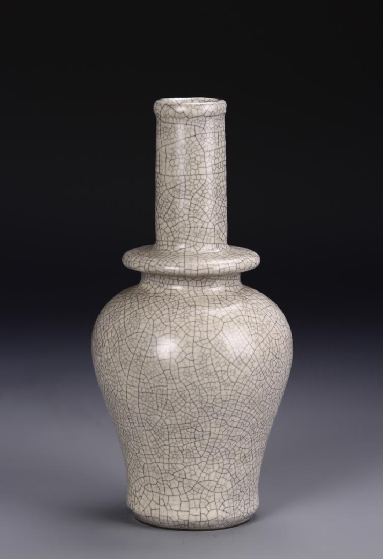 Koyao Long Neck Baluster Vase: The baluster body surmounted with a flange section rising to a tall cylindrical neck, covered allover with a densely crackled milky glaze, 9 in high. Provenance: Formerly from the collection of Carl S