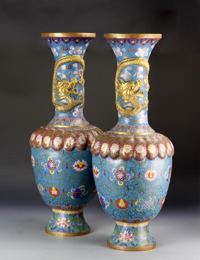 Pair of Chinese Cloisonne Vases: China, 19th C., pair of cloisonne vases, each on a raised base, rounded shoulders rising to a tall, narrow neck, embellished with a gilt image of a dragon, everted rim. Height 26 in.