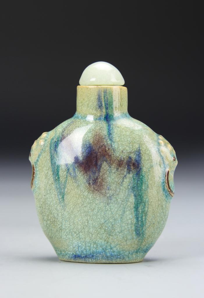 Chinese Jun Yao Snuff Bottle: China, 19th C., Jun Yao snuff bottle, with rounded shoulders and tapering neck, glazed in a mottled pale turquoise hue with subtle crackle lines, mark on base. Height 3 in.