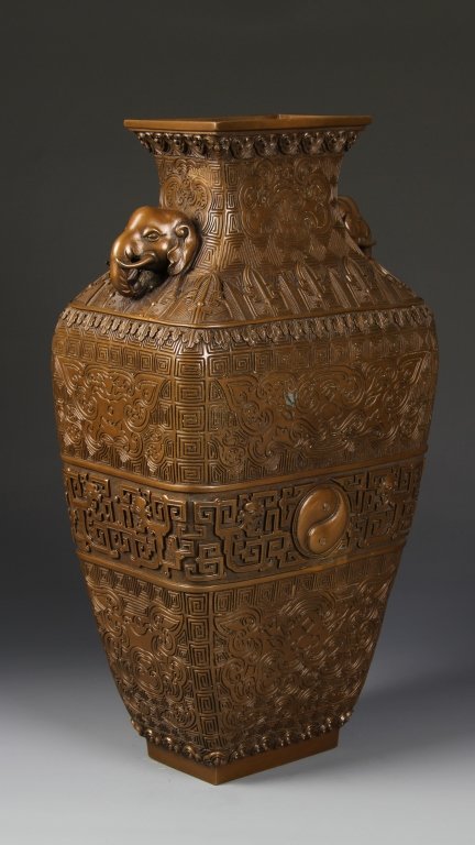 Chinese Bronze Vase: China, Qing Dynasty, bronze vase, elephant head handle, the vase is decorated with ten bands of motifs in relief including yinyang, archaic, chi dragon and auspicious symbols, Qianlong mark on base an