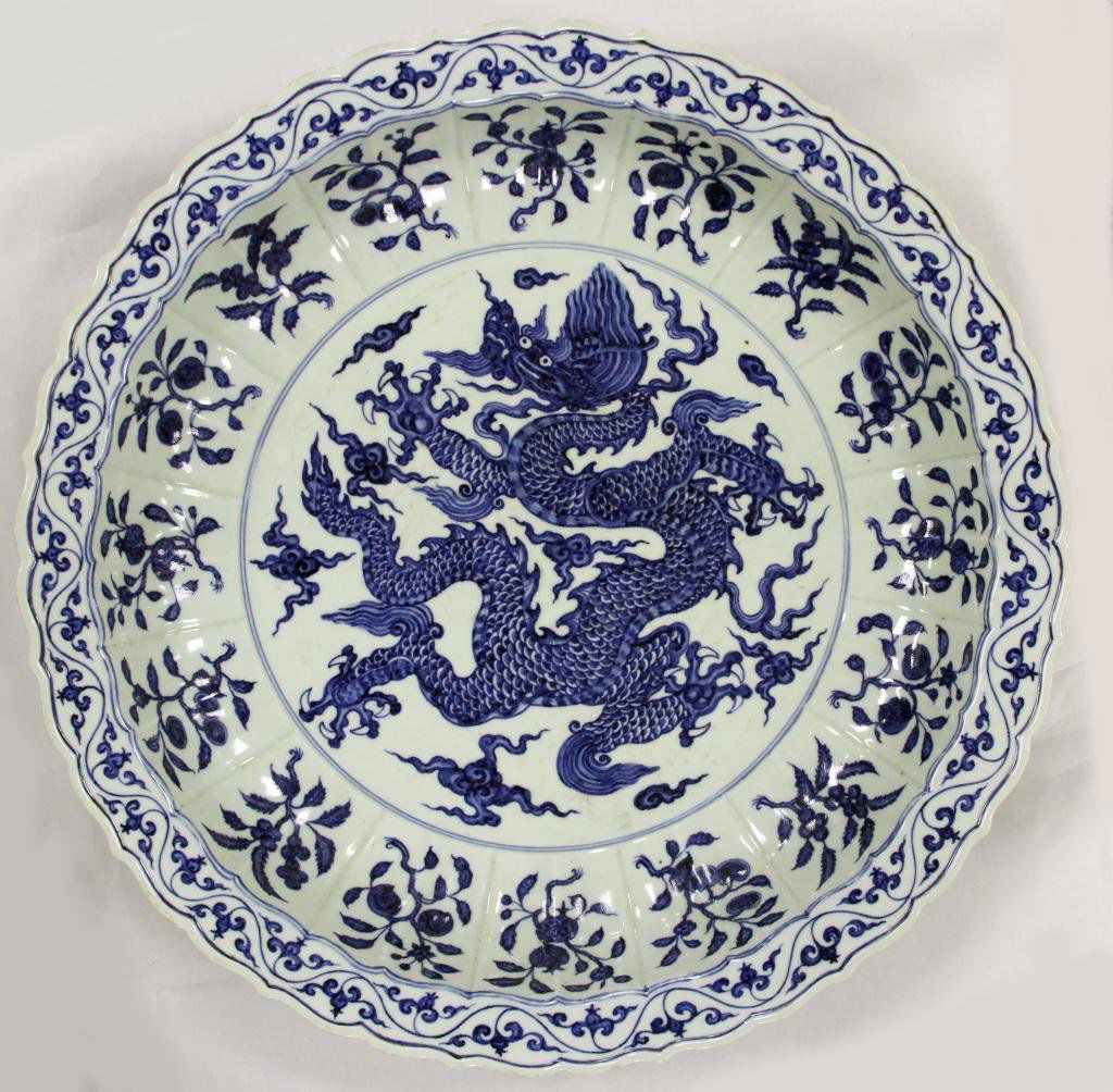 Chinese Blue and White Glazed Plate: Blue and White Glazed Plate, China. Focal point is the center dragon, which is surrounded by a repeating floral pattern. (D. 22 1/4 in.)
